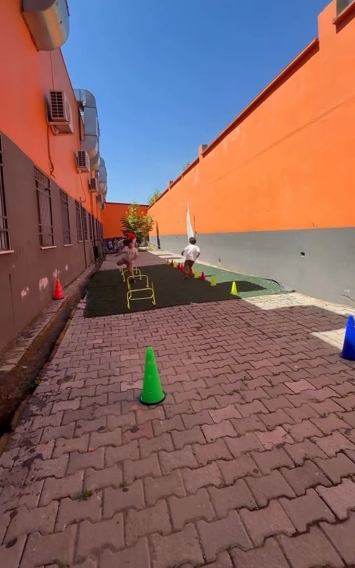 Turuncu duvarlı okul bahçesi ve çim parkur